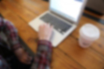 out of focus image of man working at a laptop