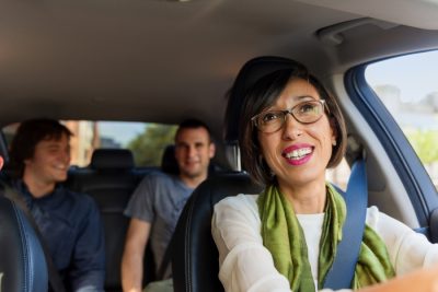 Smiling Uber driver with two passengers