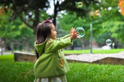 Young girl catching bubble