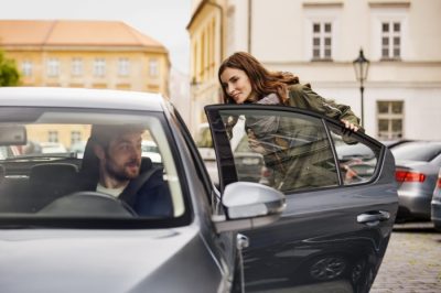 smiling Uber rider getting into car