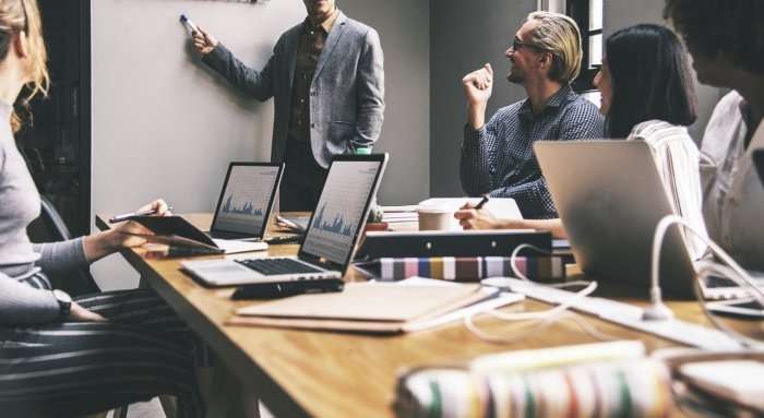 The 5 Surprising Traits That All Great Entrepreneurs Share Meeting room with laptops on table and presenter